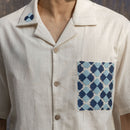 Close-up of hand-embroidered Phulkari pocket, collar motif and coconut shell buttons