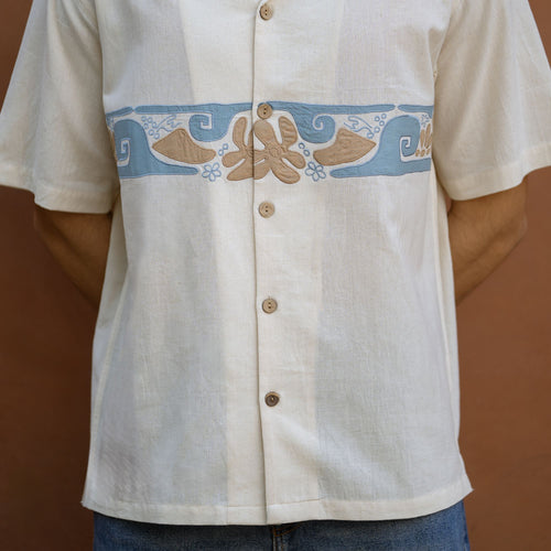 Close-up of hand-appliqued wave and flower motifs on ecru handloom khadi shirt