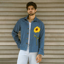 Man wearing mid blue denim shaket with hand-embroidered French knot sunflower, front view