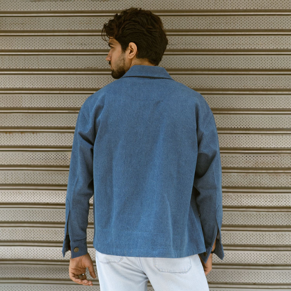Back view of mid blue 100% cotton denim shaket with one-piece collar and full sleeves