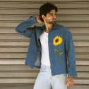 Man posing in open blue denim shaket showing embroidered French knot sunflower on the front